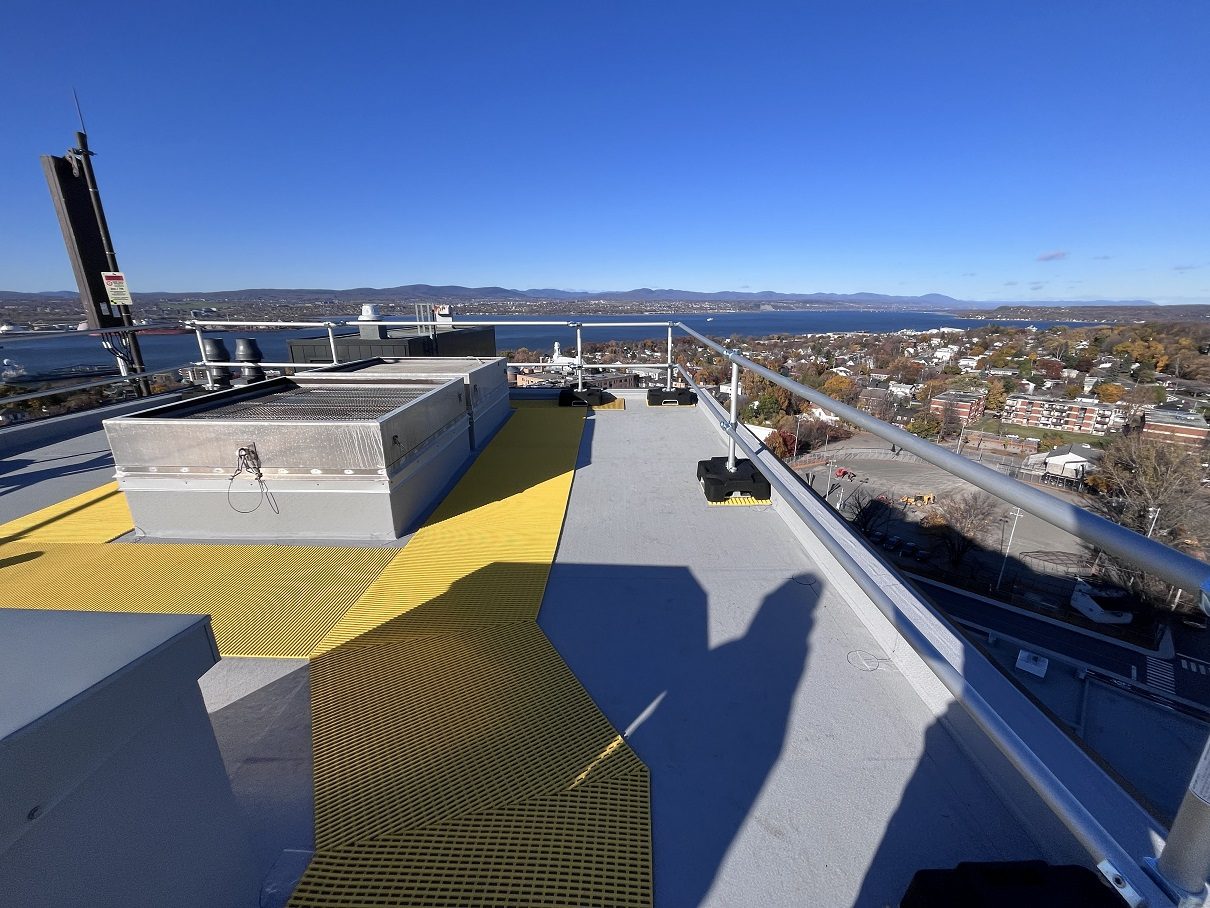 Garde-corps Compact Delta installés sur le toit de l'Hôtel-Dieu de Lévis, avec le fleuve en arrière-plan